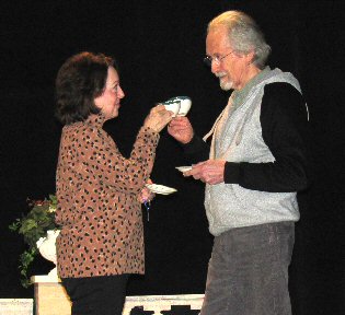 a woman and a man holding teacups